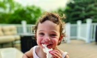 A young girl messily eating a s'more