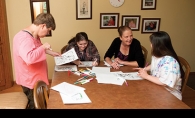 Ives House program manager Brenda Witt (in black) works with residents Anne, Lauren and Kelly. 