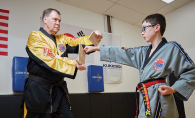 World Taekwondo Academy grand master Kevin Kastelle trains a child with special needs.