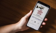 A person holding a phone listens to the New York Times podcast "The Shrink Next Door."