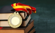 An educational award sits atop a pile of books.