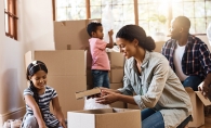 A family packs boxes, preparing for a move with kids.