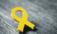 A yellow ribbon pin, signifying support for veterans.