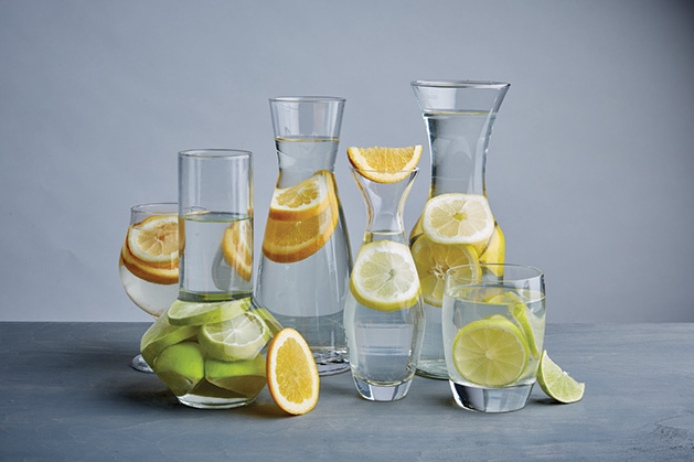 A collection of pitchers containing fruit water.