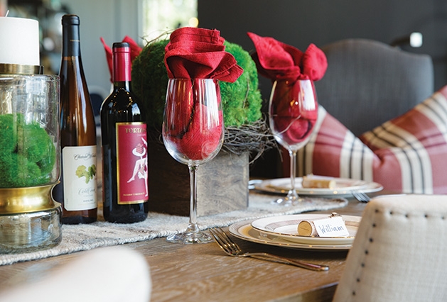 Holiday table decor A holiday table spread featuring wine and wine glasses, candles, a place setting and more.