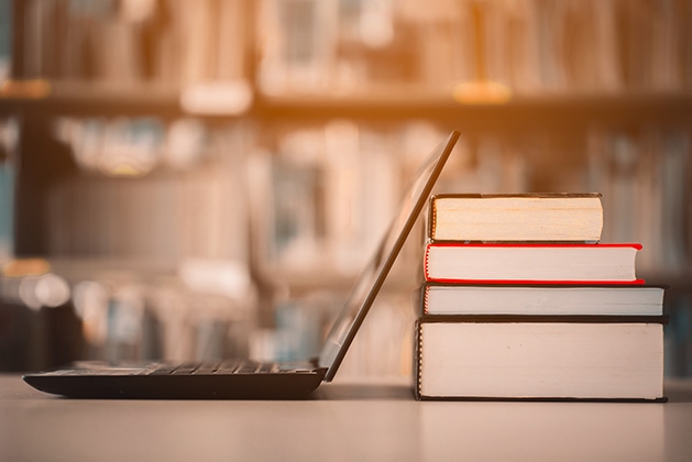 A laptop rests against some books at the library.