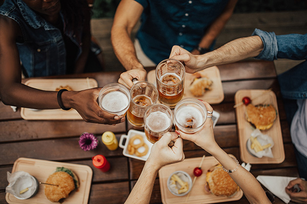 A group of friends enjoys happy hour food and drink.