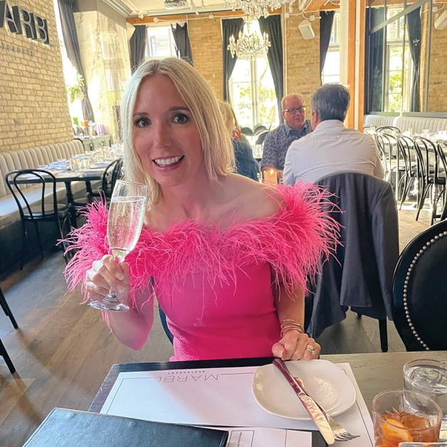 Nikki Steele wearing a pink dress with feather trim.