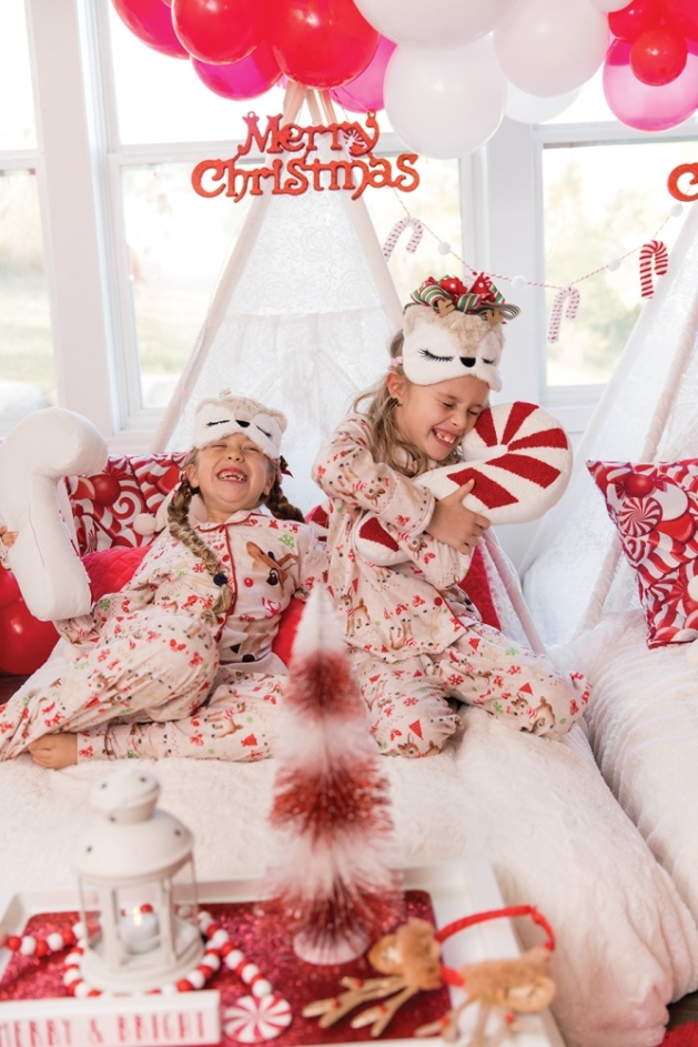 Two young girls enjoying a holiday sleepover setup.