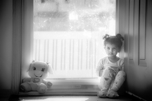 A girl sits six feet from her stuffed animal.