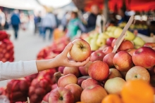 Someone shopping fresh apples at a farmer's market.