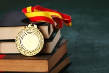 An educational award sits atop a pile of books.