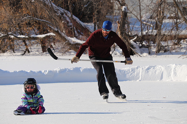 A dad and his child ice skating.