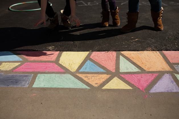 Ann Grocholski and her children work on a sidewalk chalk mural.